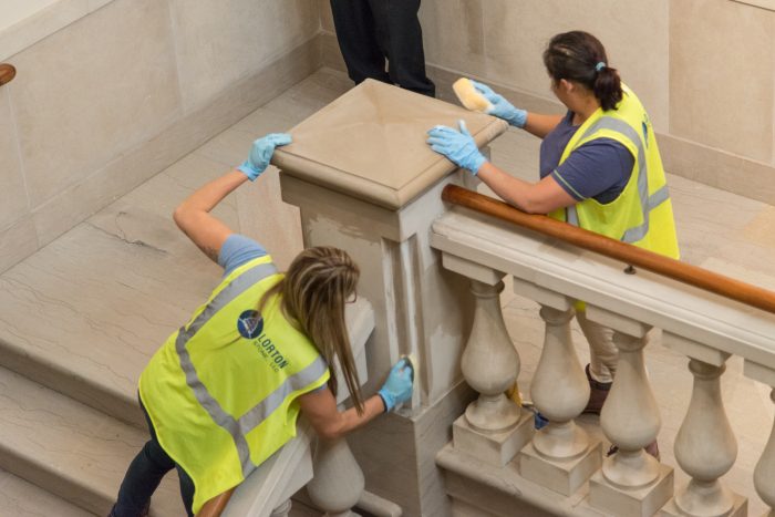 cleaning crew works on marble staircase