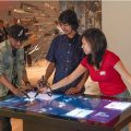 Visitors use digital pen on large touch screen