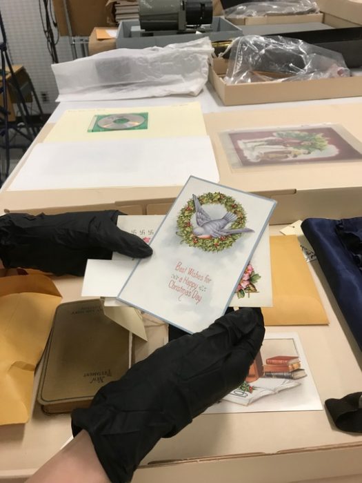 Curator wearing gloves displays holiday card