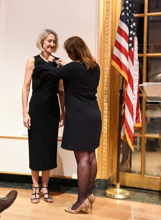 Woman pins award to Baumann's dress