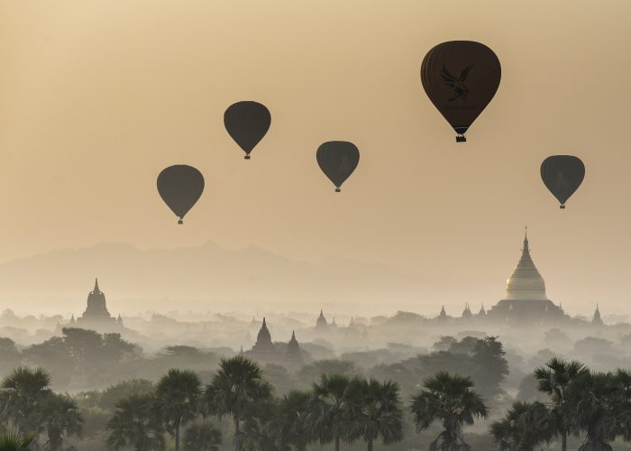 A view of temples and the surrounding landscape at dawn in the Bagan area of Myanmar.