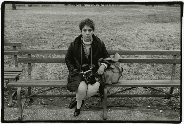 Black and white photo of Arbus sitting on bench