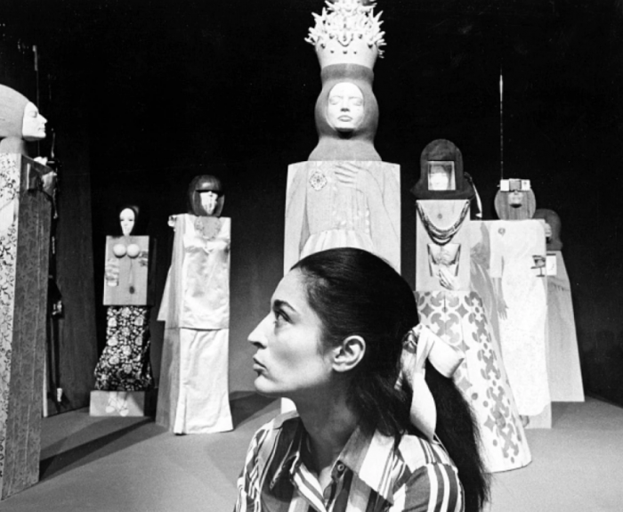 B&W photo of artist with sculptures