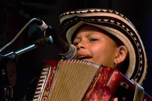 close up of child playing accordion and singing