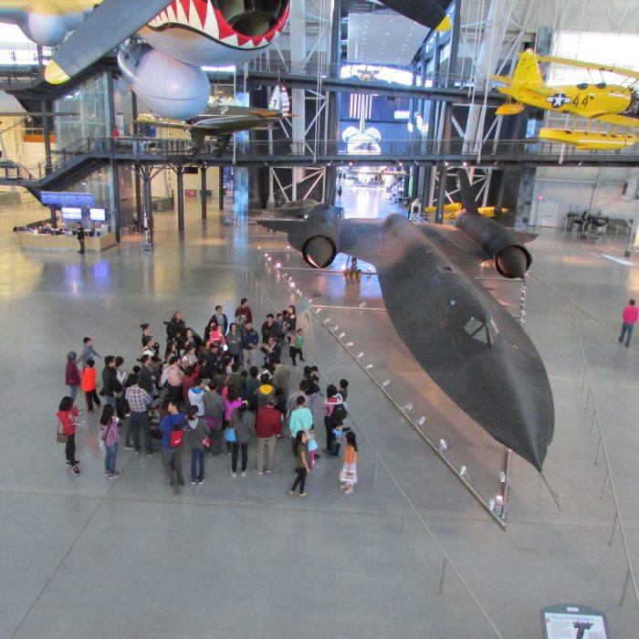 Crowd gathers around aircraft in hangar