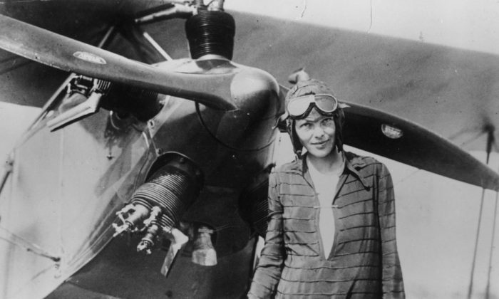 Amelia Earhart in front of prop plane