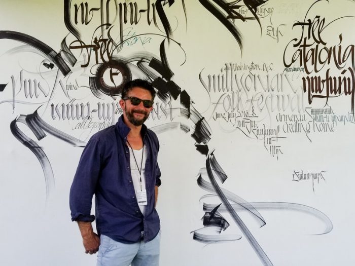 Artsts in front of wall of his calligraphy