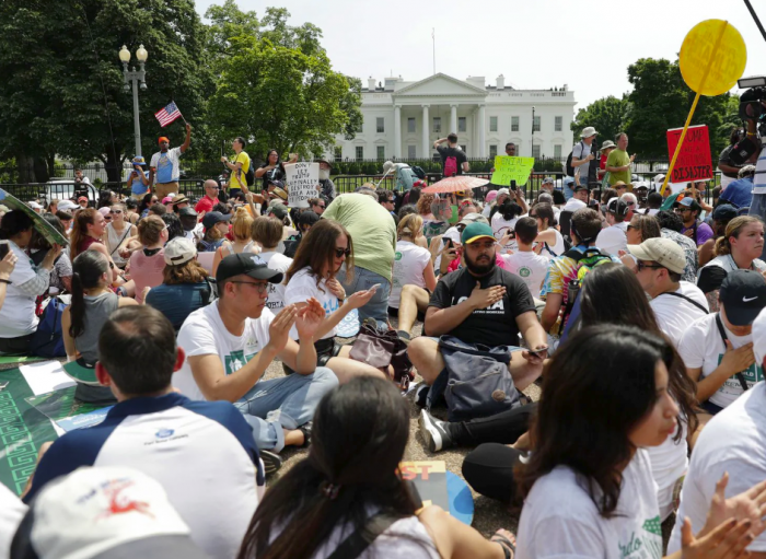 Crowd sitting in park in front of White house