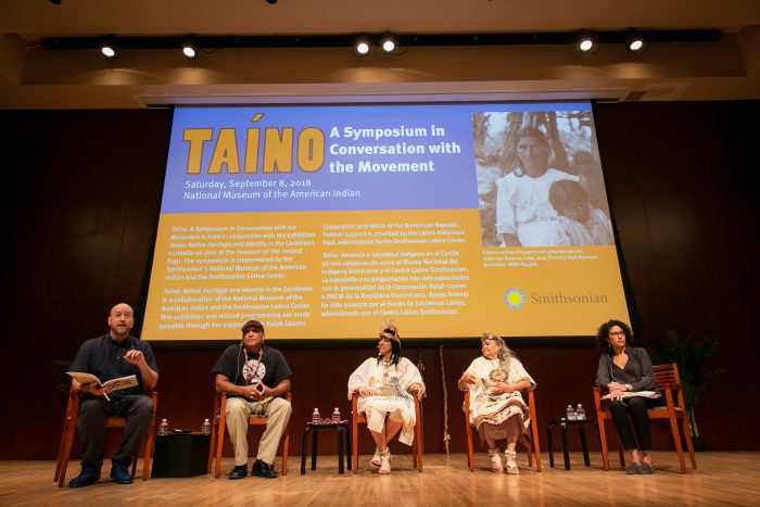 Panel of five people seated on stage