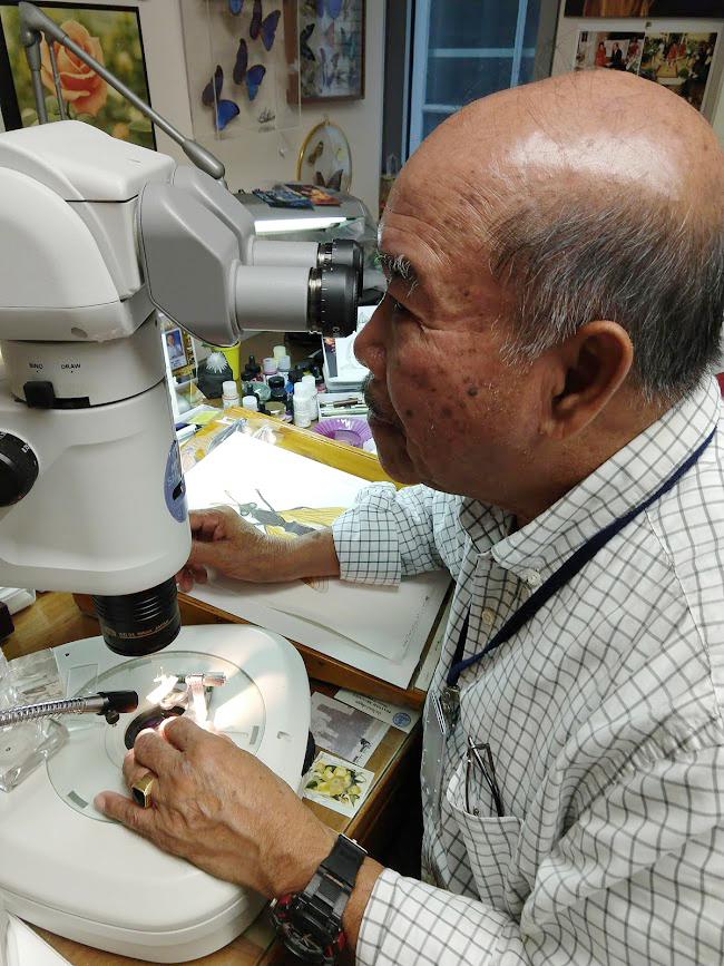 Vichai peering through microscope