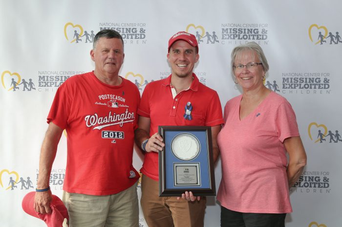 Gagliardi family pose in front of NCMEC screen