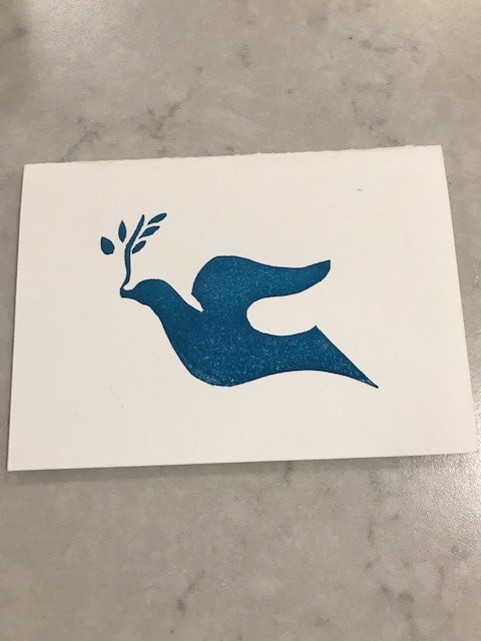 Stencil of blue dove on paper