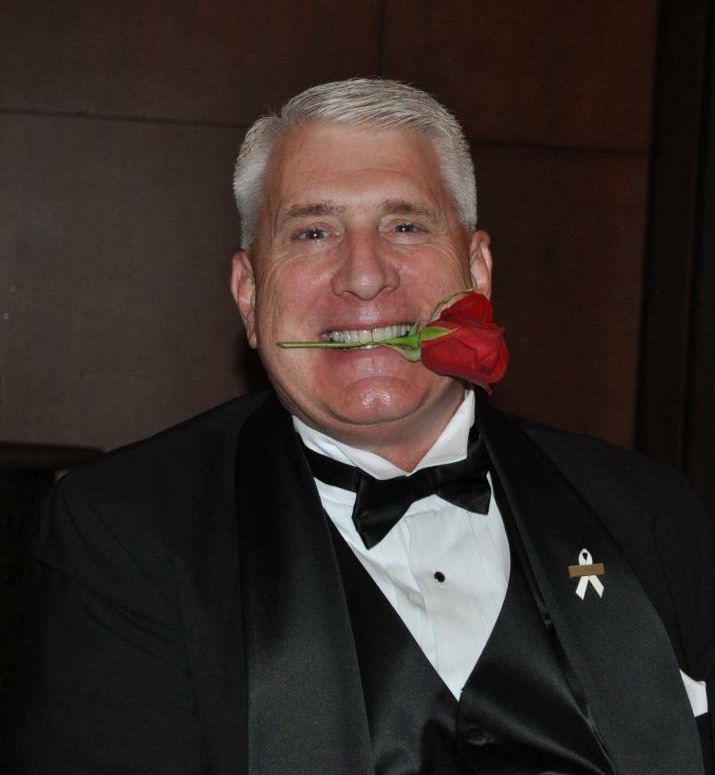 Peterson in tuxedo with rose in his teeth