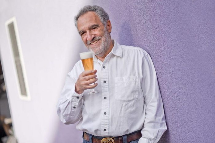 Papazian holding glass of beer