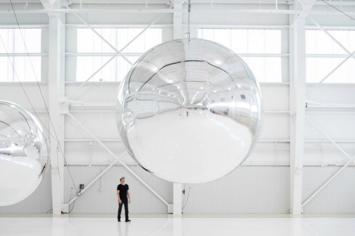 Artist in front of spherical installation