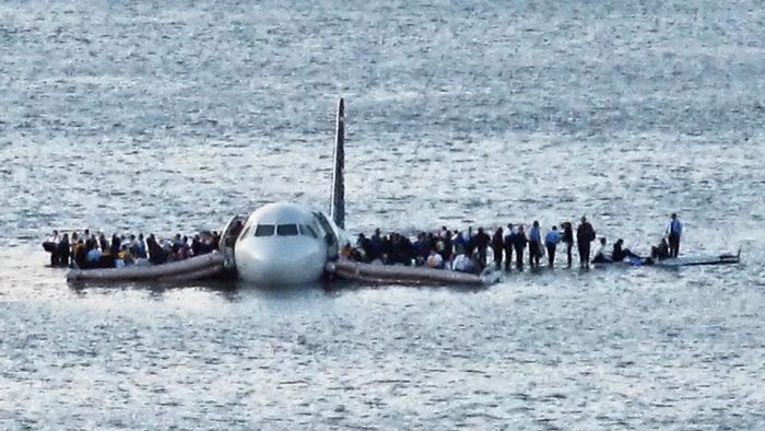 Passengers standing on wings of downed plane