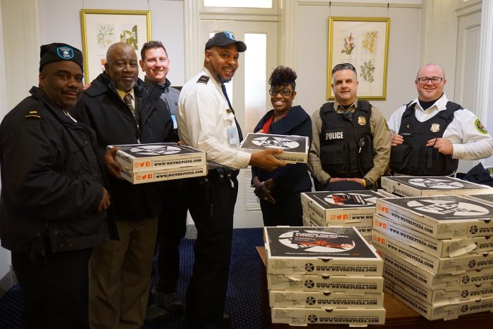 Security officers collecting donated pizzas