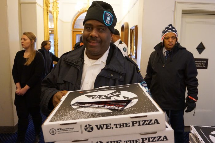 Ellis holding several pizzas