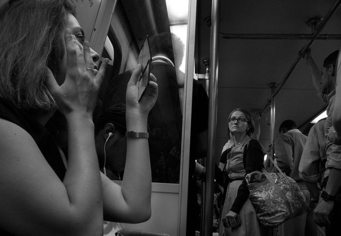 Woman doing her makeup on Metro train