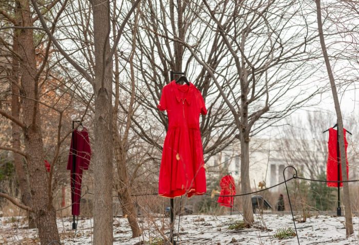 Red dresses hanging among trees