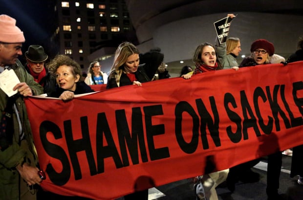 Protesters holding red banner "Shame on Sackler"
