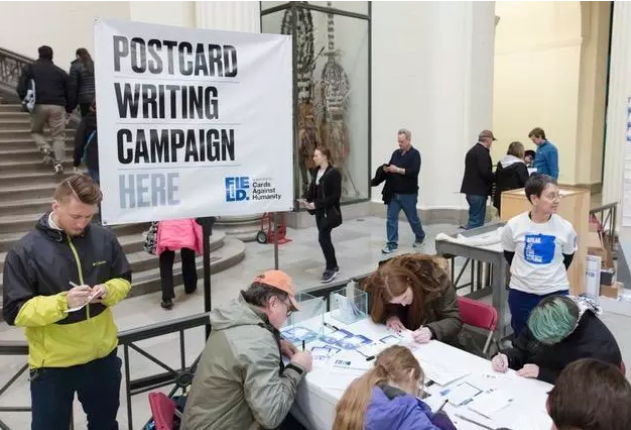 Visitors signing postcards