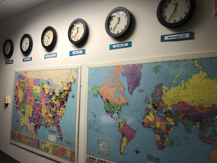 Wall maps marked with flags and clocks set to different times