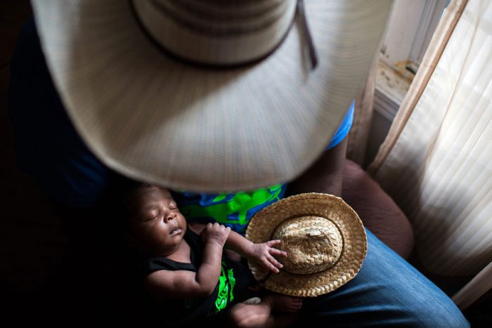 Man looks down at infant in his lap