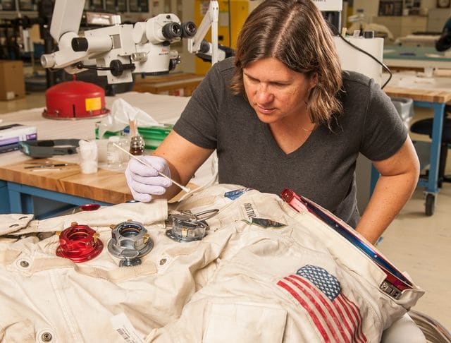 Conservater works on spacesuit
