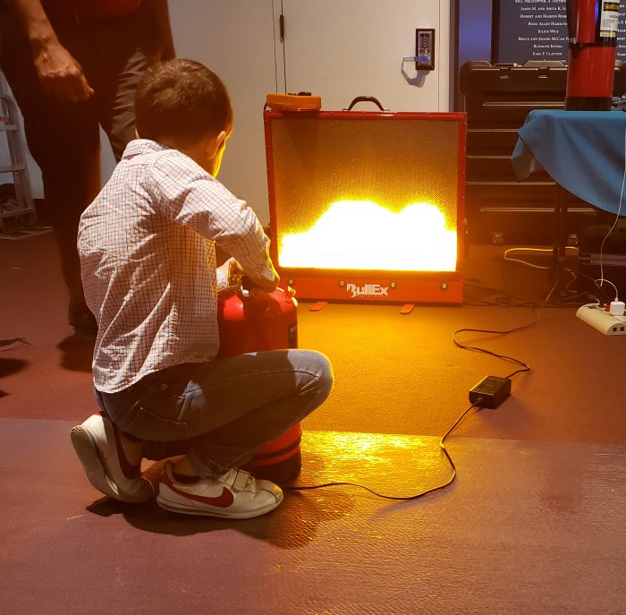 Child aims fire extinguisher at simulator screen