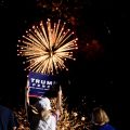 Supporter holding Trump sign with fireworks in background