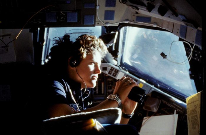 Sullivan looking through window of space shuttle