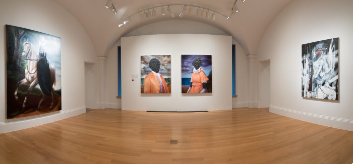 Gallery view of exhibition with with dual portraits as focal point