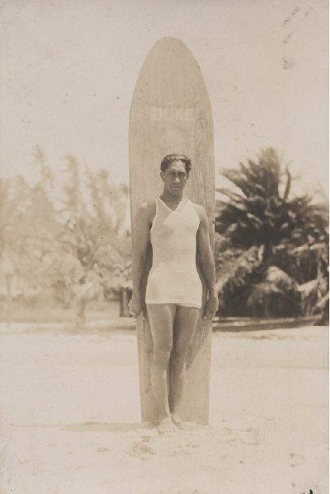 Duke posing with hand-carved longboard