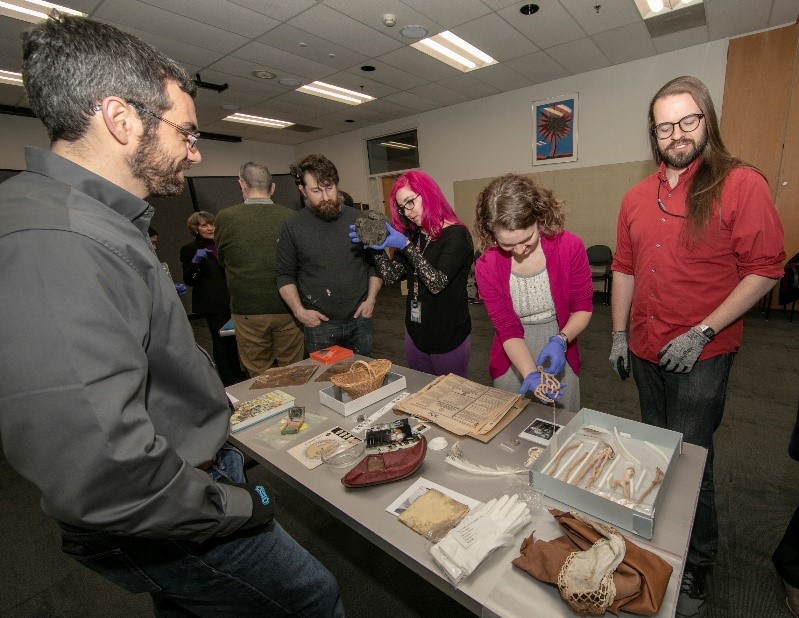 People gathered around table at Collections Open House