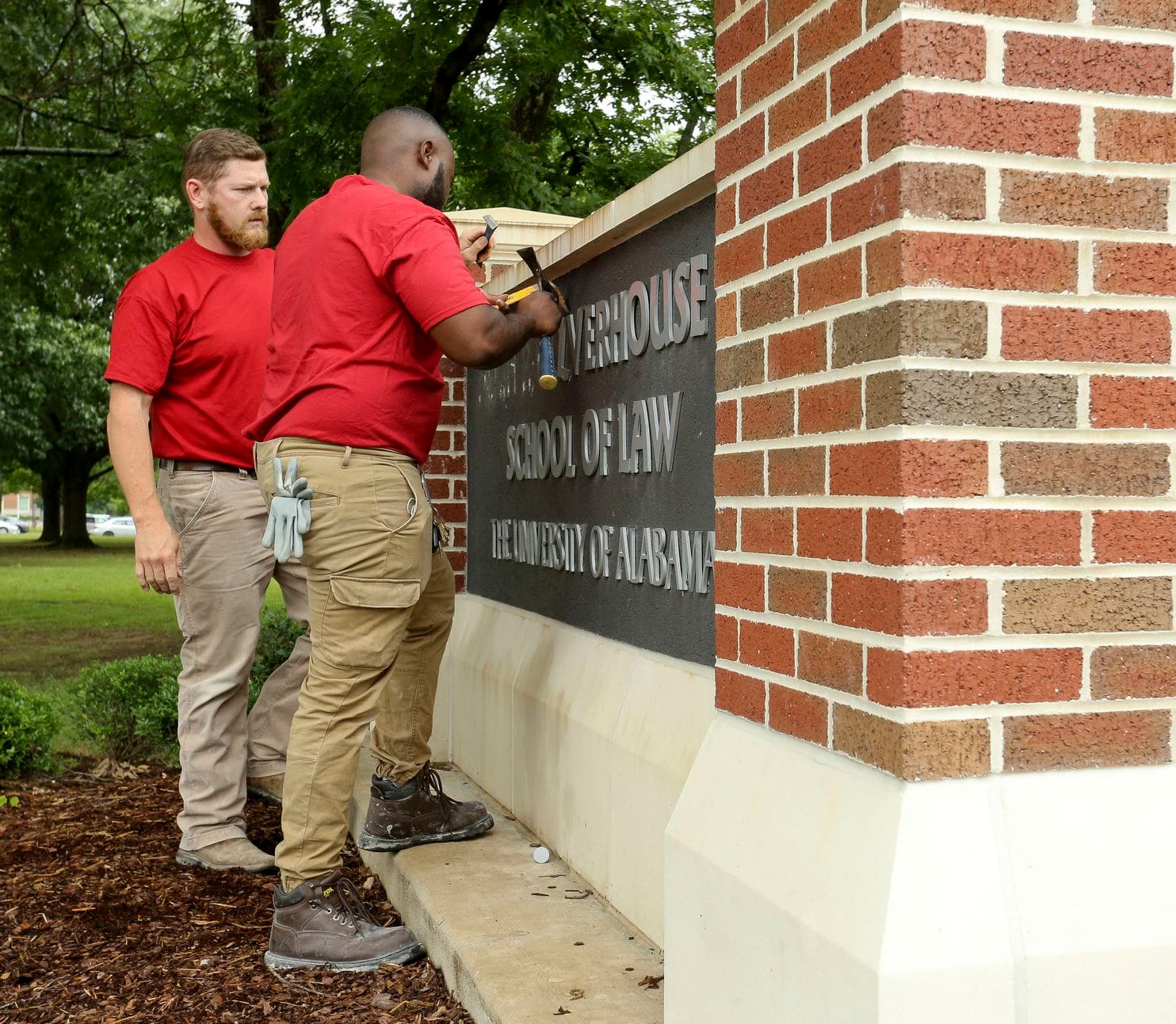 Workers removing letters from sign