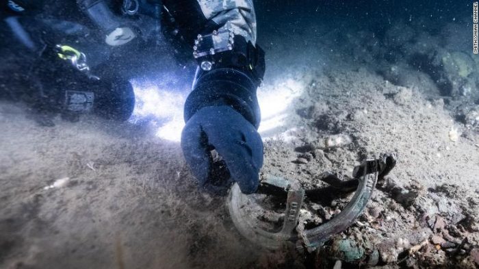 Video still of diver with artifact