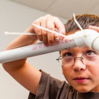 Child working with PVC pipe