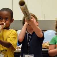 Kids playing with cardboard tubes