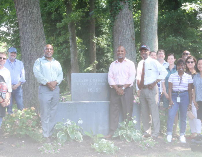 Mixed race family group poses around tombstone