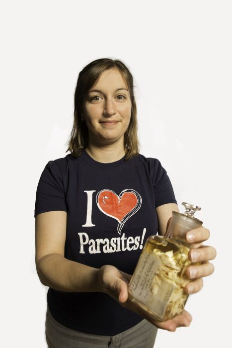 Anna Philips holding jar of parasites, wearing t shirt that sauys "I Love Parasites"