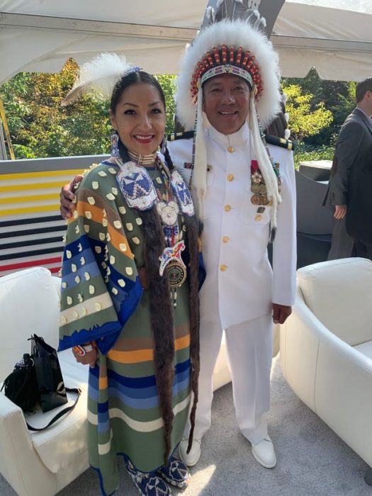 Couple at groundbreaking, one in uniform, one in Native dress. 