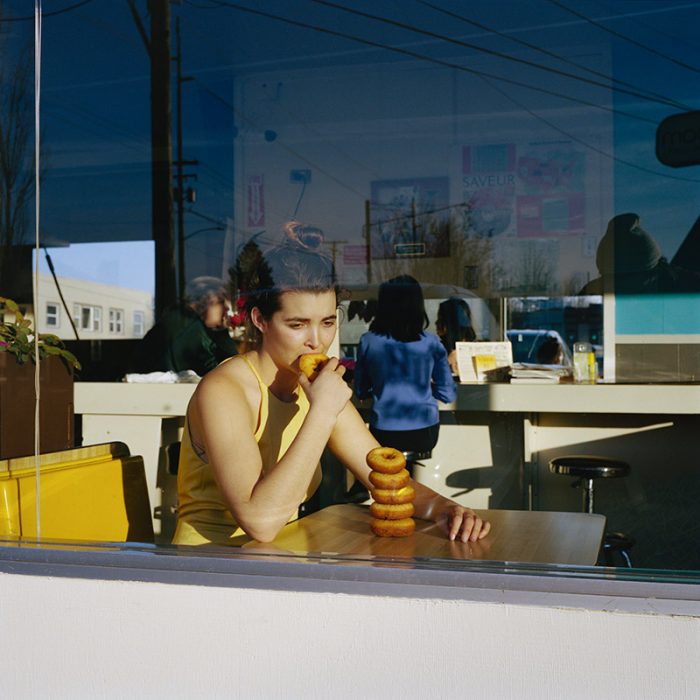 Woman in diner eating donuts