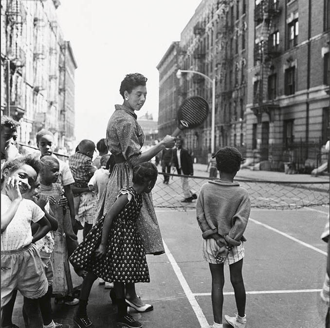 Gibson, with tennis racket, among young children on city street