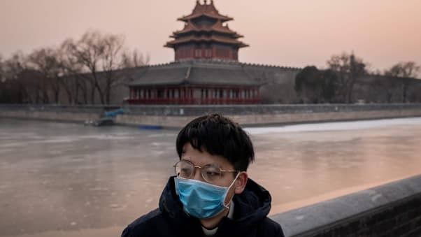 Man wearing mask in front of palace