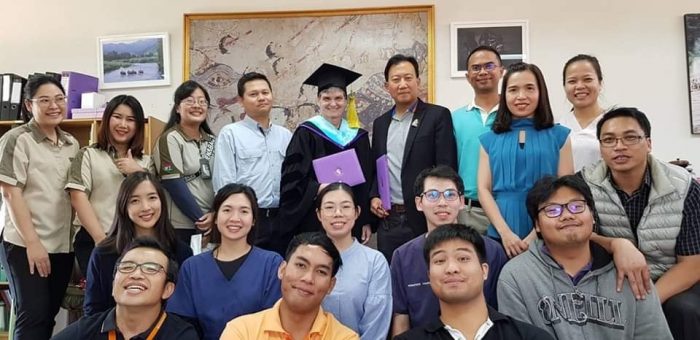 Brown in academic robes with friends