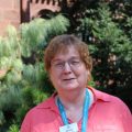 Woman in pink shirt with pine trees in background