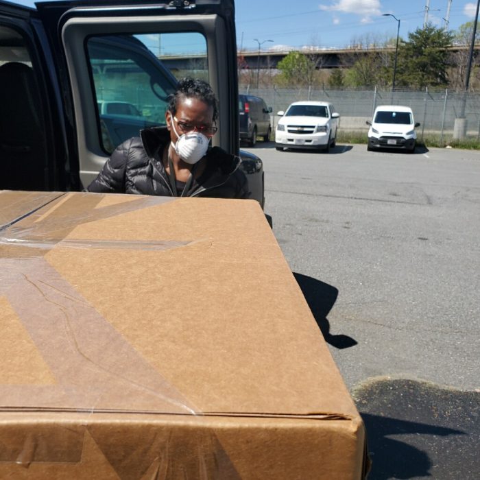 Woman unloading boxes from truck