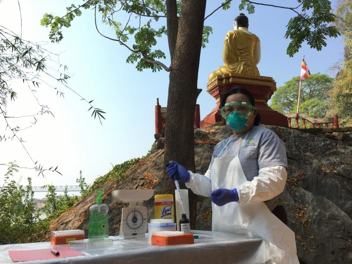 Woman in the field wearing mask and collecting samples