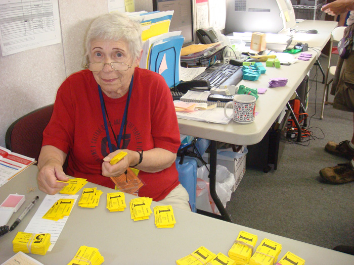 Volunteer in red t-shirt counting yellow tickets